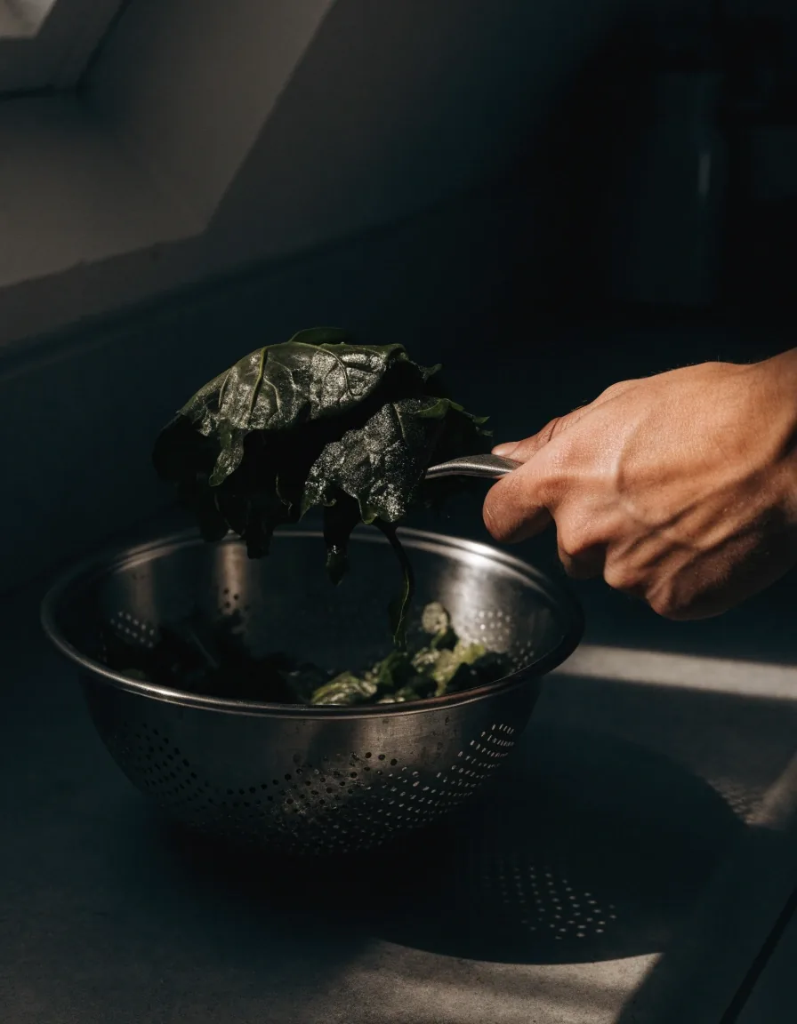 Ruke režu mango na drvenoj dasci pod jednim izvorom svjetla